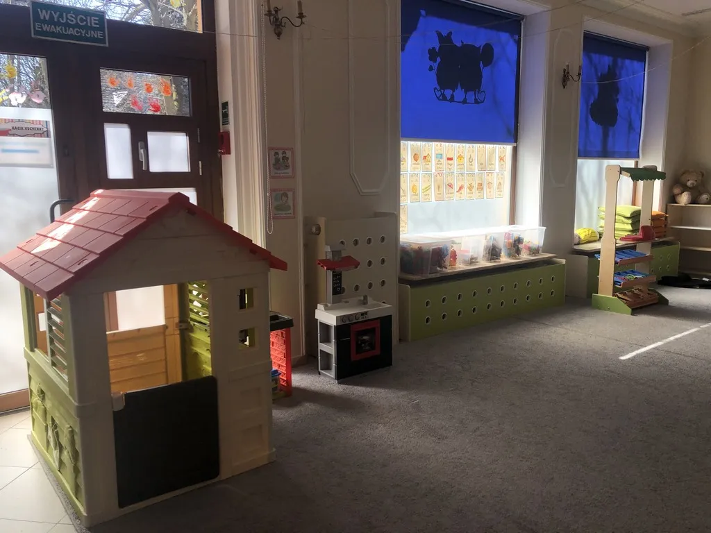 Sala przedszkolna z drewnianym domkiem do zabawy